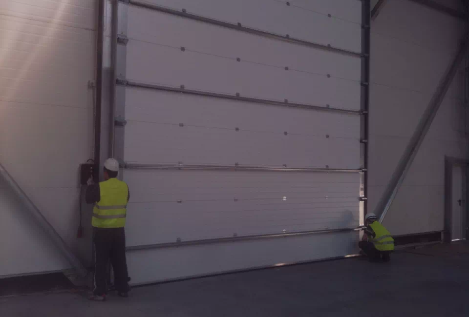Pracownicy montujący bramę garażową